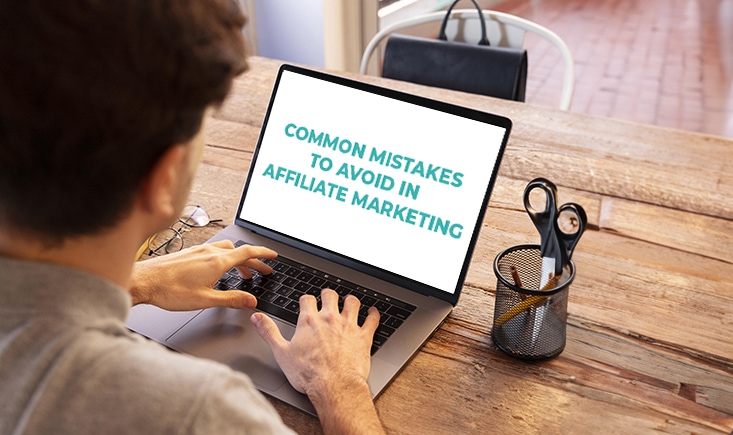 Image of a person looking at a laptop with text "common mistakes to avoid in affiliate marketing"